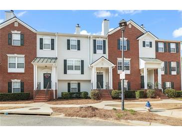 Attractive townhome exteriors featuring brick and siding, complemented by well-maintained landscaping at 240 Village Square Dr, Woodstock, GA 30188