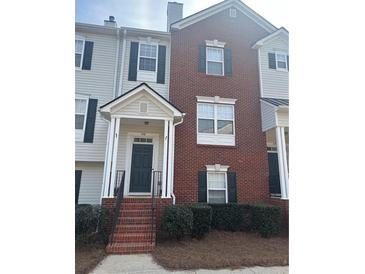 Charming townhome with a brick facade, covered entrance, and well-maintained landscaping at 240 Village Square Dr, Woodstock, GA 30188