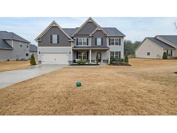 Charming two-story home with a well-manicured lawn and inviting front porch at 388 Greighmoor Ct, Loganville, GA 30052