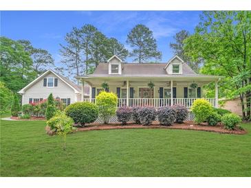 Charming home featuring a welcoming front porch and lush landscaping at 1870 Shoreline Trce, Grayson, GA 30017