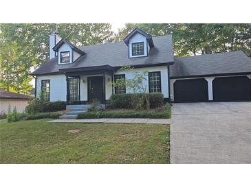 Charming home featuring a two-car garage, dormer windows, and a well-manicured front lawn at 1947 Kensington High Sw St, Lilburn, GA 30047