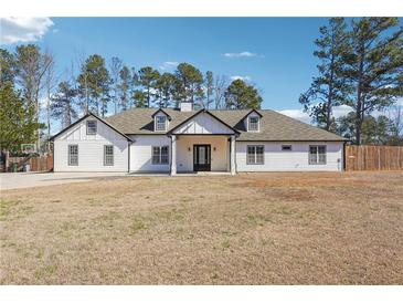 Charming white home featuring a large front yard and a classic American farmhouse design at 1243 Old Villa Rica Rd, Dallas, GA 30157