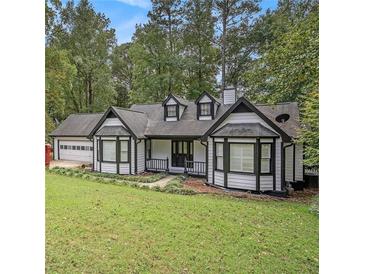 Charming one-story home featuring white siding, black trim, a covered porch, and an attached two car garage at 4902 Cedar Se Ct, Conyers, GA 30094