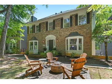 Charming brick home featuring a front patio with a fire pit and cozy Adirondack chairs at 2316 Defoors Ferry Nw Rd, Atlanta, GA 30318