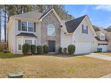 Charming two-story home featuring stone accents, a well-maintained lawn, and attached two-car garage at 1116 Oak Hollow Ln, Hampton, GA 30228