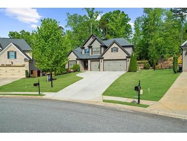 Charming two-story home featuring a well-manicured lawn and a three-car garage at 1605 Camden Cove Dr, Cumming, GA 30040