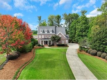 Beautiful brick home featuring mature trees, a long driveway and lush landscaping at 4992 Price Dr, Suwanee, GA 30024