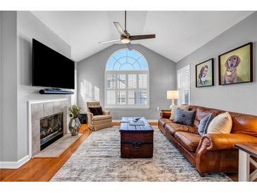 Bright living room with hardwood floors, large windows, and cozy fireplace at 22107 Harvest Ridge Ln # 22, Alpharetta, GA 30022