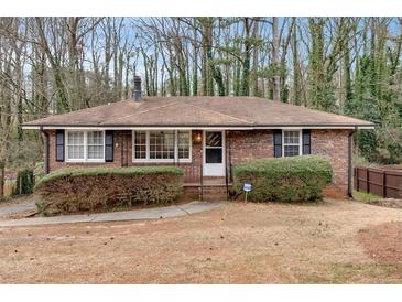 Charming brick home with manicured bushes and black shutters on a sunny day at 2344 Hollyridge Sw Dr, Marietta, GA 30060