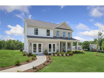 Charming two-story home with a brick and siding exterior, a manicured lawn and a welcoming front porch at 371 Foxglove Way, Mcdonough, GA 30253