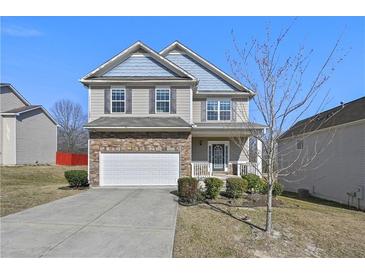Charming two-story home featuring a stone-accented front, attached garage, and inviting front porch at 1566 Wilson Manor Cir, Lawrenceville, GA 30045
