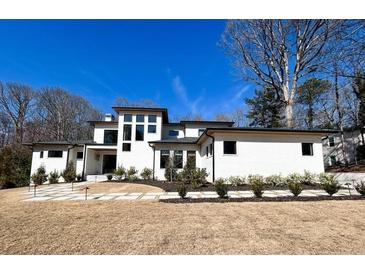 Stunning modern home featuring a white brick exterior, manicured landscaping, and a walkway leading to the entrance at 4524 Mystic Dr, Sandy Springs, GA 30327