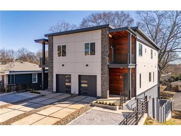 Modern two-story home featuring a two-car garage, stone accents, and balconies at 147 Hutchinson Ne St, Atlanta, GA 30307