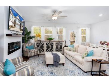 Bright living room with a fireplace, ceiling fan, and plenty of natural light at 269 Whitetail Cir, Canton, GA 30115