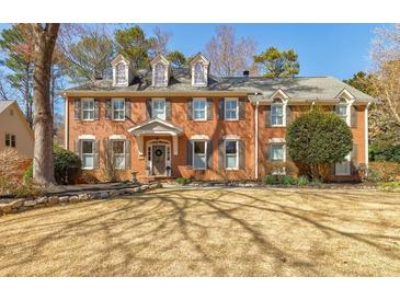 Traditional red brick home with dormer windows and manicured lawn at 656 Gunby Se Rd, Marietta, GA 30067