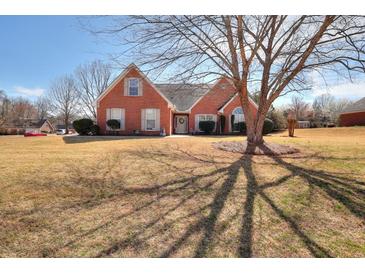 Charming brick home featuring manicured landscaping, classic shutters, and a welcoming front entrance at 1500 Elena Dr, Mcdonough, GA 30253