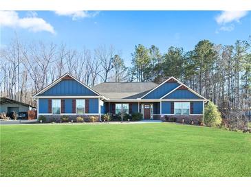 Charming blue home featuring a well-manicured lawn and stone accents at 316 Cranmore Pl, Villa Rica, GA 30180