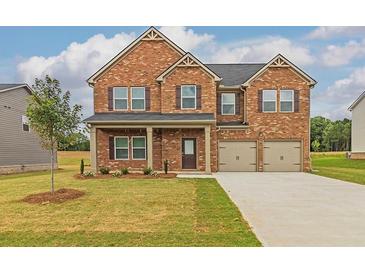 Two-story brick home featuring a well-manicured lawn, two-car garage, and inviting front porch at 300 Bianca Way, Mcdonough, GA 30253