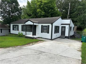 Charming single-story home with white siding, black trim, and well-maintained front yard at 1298 Belmont Se Ave, Smyrna, GA 30080