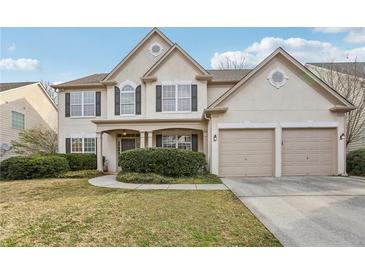 Charming two-story home featuring a manicured lawn and a two-car garage at 1307 Calderwood Se Ct, Smyrna, GA 30080
