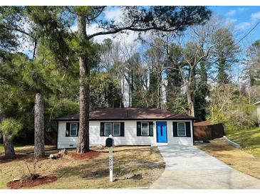 Charming single-story home featuring a blue front door, fresh landscaping, and a driveway at 2745 Marco Nw Dr, Atlanta, GA 30318