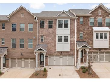 Charming brick townhome with well-maintained landscaping, front entryway, and two car garage at 1336 Rosen Rd, Brookhaven, GA 30319