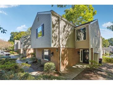 Charming townhome with a brick facade, complemented by mature trees and lush landscaping at 30 Dunwoody Springs Dr, Atlanta, GA 30328