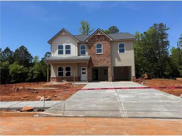 Two-story home featuring brick and vinyl siding with an attached two-car garage and newly poured concrete driveway at 1590 Sungrown Way, Mcdonough, GA 30253