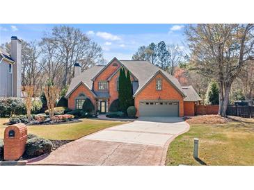 Beautiful brick two-story home with a well-manicured lawn and attached two-car garage at 6715 Brookline Ct, Cumming, GA 30040