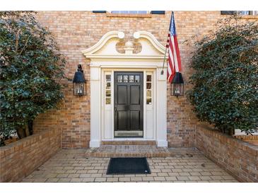 Charming brick home featuring a stylish front door with sidelights and decorative trim at 7690 Classic Way, Atlanta, GA 30350