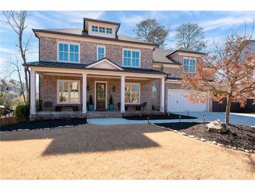 Charming two-story brick home with a welcoming front porch and well-manicured lawn, exuding curb appeal at 14 Long Island Pl., Atlanta, GA 30328