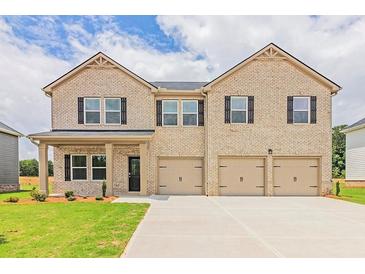 Charming two-story home with a three car garage, brick facade, and well-manicured lawn at 1598 Sungrown Way, Mcdonough, GA 30253
