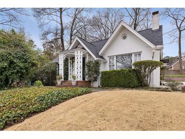 Charming home featuring a white exterior, covered porch, and professionally landscaped yard at 2044 Cottage Nw Ln, Atlanta, GA 30318