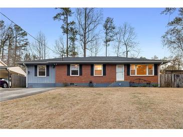Charming single-story brick home with a manicured front lawn and a convenient carport at 1893 Kenwood Se Rd, Smyrna, GA 30082