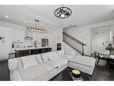 Open concept living space with modern kitchen, hardwood floors, and staircase at 3933 Danube Ln # 221, Atlanta, GA 30339