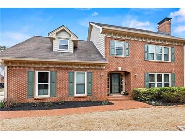 Charming two-story brick home featuring green shutters, brick walkway, and well-manicured landscaping at 2976 Wilsons Crossing Ct, Decatur, GA 30033