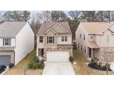 Two-story home featuring stone accents, neutral colors, and an attached two-car garage at 5015 Rapahoe Trl, Atlanta, GA 30349