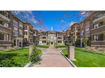 Attractive brick apartment buildings with arched entryway and well-manicured landscaping under a bright blue sky at 198 Ponce De Leon Ne Ave # 2A, Atlanta, GA 30308