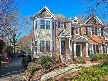 Charming townhome featuring a blend of brick and siding, complemented by mature landscaping at 1580 Commerce Dr # A8, Decatur, GA 30030