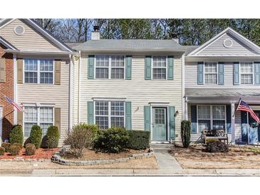 Inviting two-story townhome with light yellow siding and charming green shutters at 2280 Whitestone Pl, Alpharetta, GA 30005