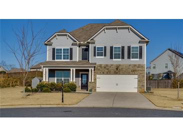 Charming two-story home with a stone facade and well-manicured lawn in a suburban neighborhood at 4675 Dandelion Way, Cumming, GA 30040