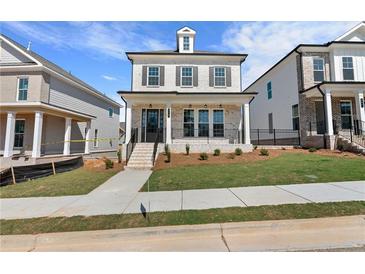 Beautiful two-story brick home featuring a charming front porch and manicured lawn at 175 Basil St, Cumming, GA 30040
