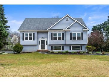 Charming two-story home featuring a well-manicured lawn and traditional architectural details at 3165 Pucketts Mill Rd, Buford, GA 30519