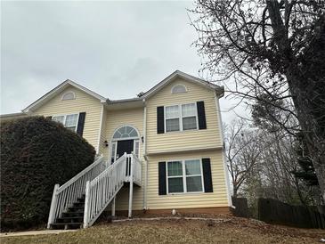 Inviting two-story home featuring a welcoming front porch and well-maintained landscaping at 2655 Fort Apachee Trl, Dacula, GA 30019
