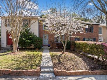 Charming townhome featuring a manicured lawn with mature trees and flowering shrubs in a desirable neighborhood at 288 Roswell Commons Cir, Roswell, GA 30076