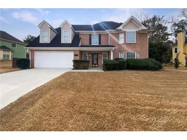 Charming two-story brick home featuring a spacious front yard and attached two-car garage at 439 Emerald Trce, Jonesboro, GA 30236