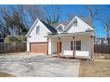 Charming two-story home featuring a brick facade, wood porch columns, and a concrete driveway at 1589 Mims Sw St, Atlanta, GA 30314