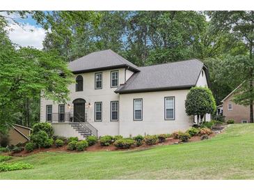 Charming two-story home with a well-manicured lawn and lush landscaping creating a welcoming curb appeal at 2819 Saddlebrook Nw Way, Marietta, GA 30064