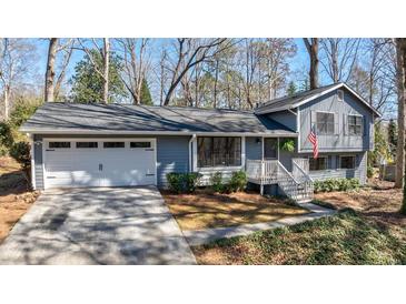 Charming blue two-story home with an attached garage, landscaped yard, and inviting entrance at 3594 Vinyard Way, Lawrenceville, GA 30044