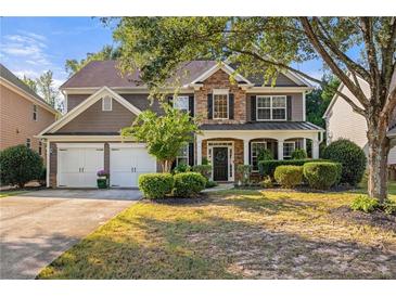 Beautiful two-story home with stone accents, manicured landscaping, and a two-car garage at 4770 Shiloh Springs Rd, Cumming, GA 30040